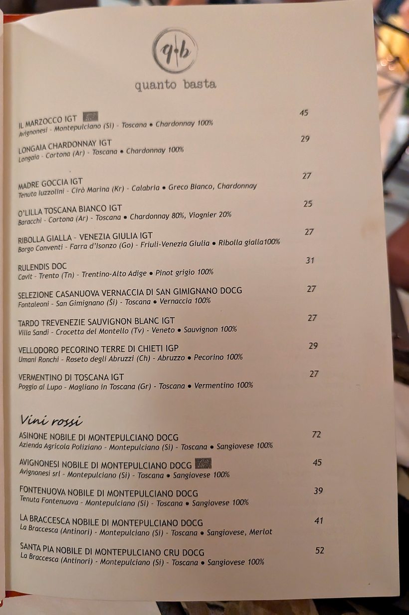 Una pagina della carta dei vini di Quanto Basta, con il marchio q·b stampato in testa alla pagina