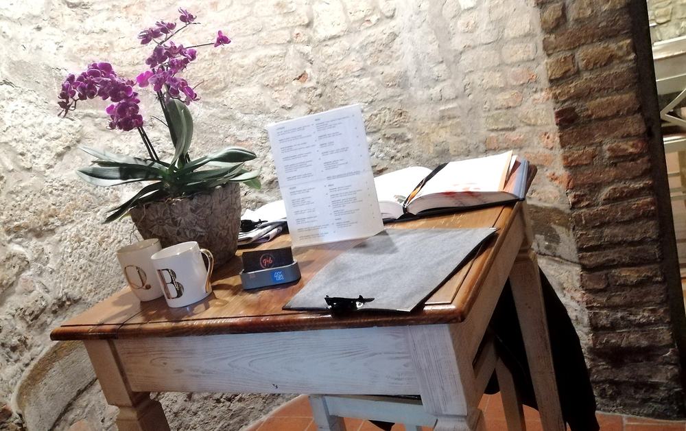Il libro degli ospiti aperto sul bancone d'ingresso, accanto a una pianta