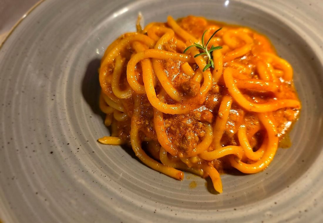 Pici al ragù di Chianina in un piatto fondo: la pasta è tirata a mano, di spessore irregolare